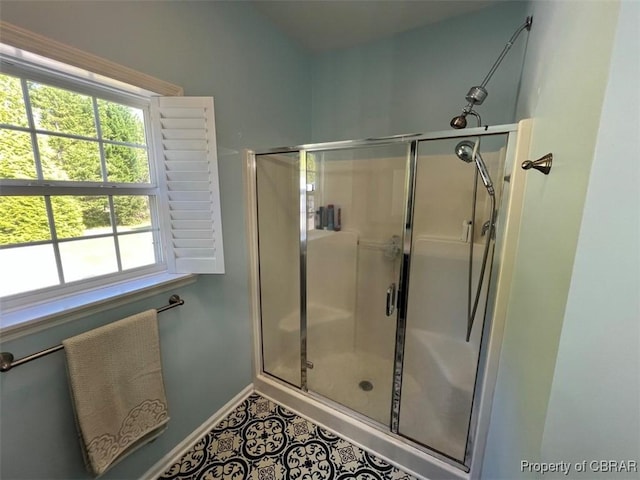 full bath featuring baseboards, a wealth of natural light, and a stall shower