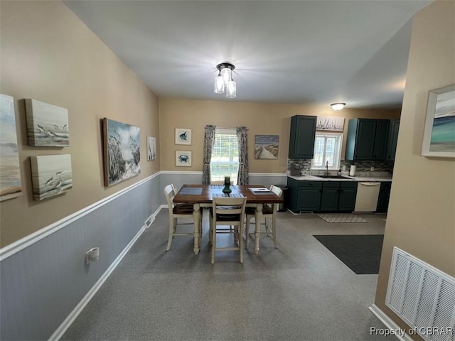 dining space featuring visible vents and a wainscoted wall