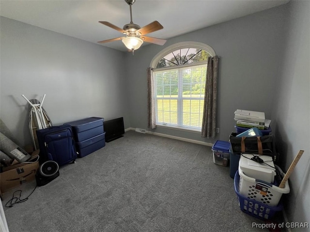 misc room with baseboards, a ceiling fan, and carpet