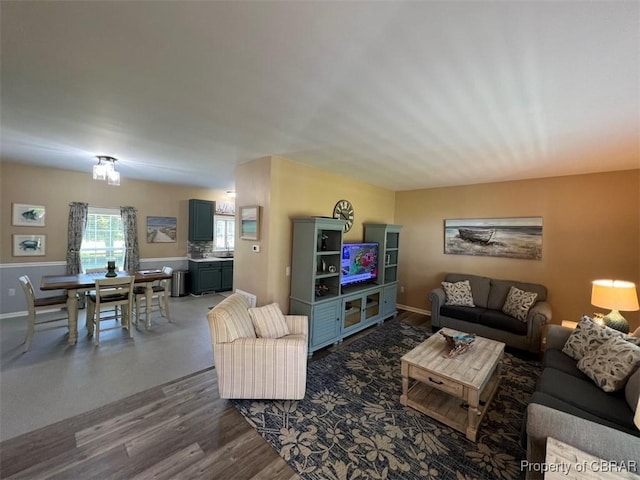 living area with baseboards and dark wood-type flooring