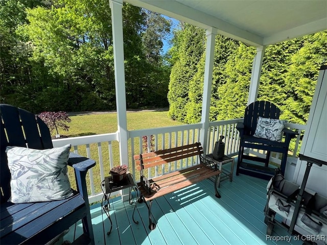 deck featuring covered porch and a yard