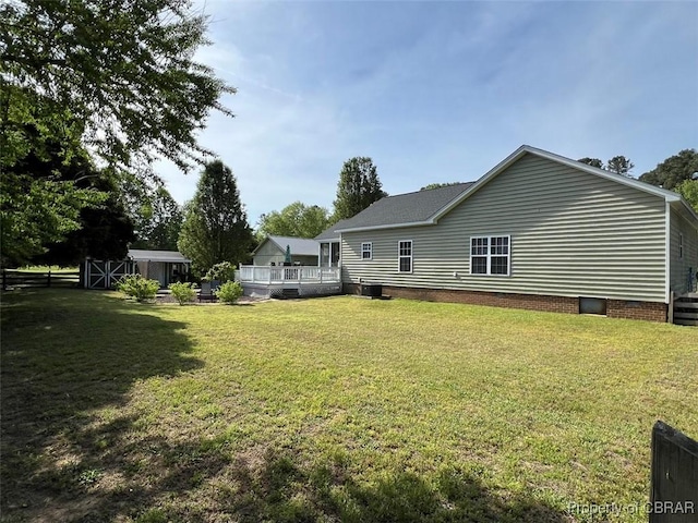 rear view of property with a yard, a deck, and crawl space