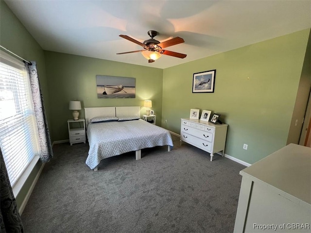bedroom with dark colored carpet, baseboards, and ceiling fan