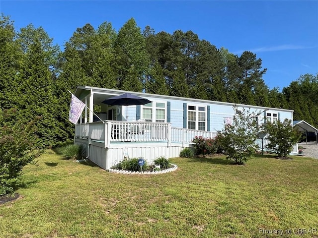 view of front of home with a front yard and a deck