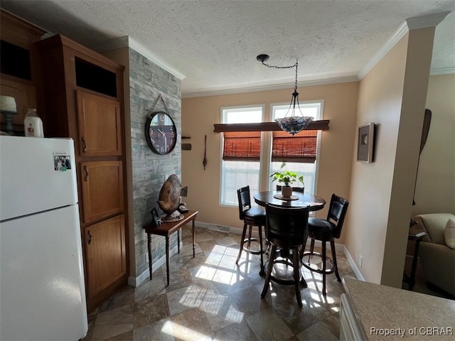 dining space with crown molding, a textured ceiling, baseboards, and stone finish floor