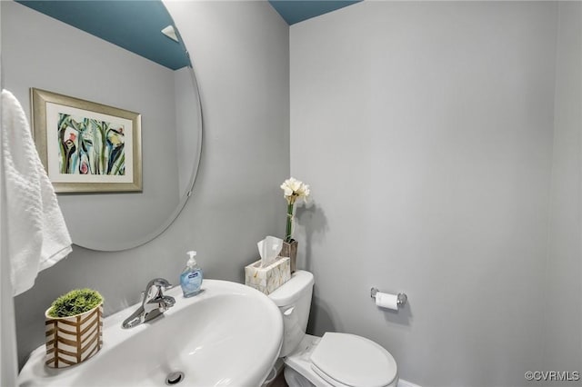 bathroom with a sink, baseboards, and toilet