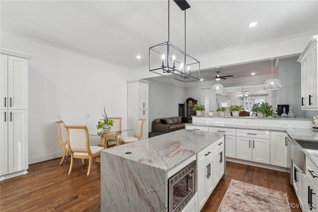 1910 Rose Ave, Richmond, VA 23222 - kitchen featuring crown molding, open floor plan, stainless steel microwave, and light stone counters