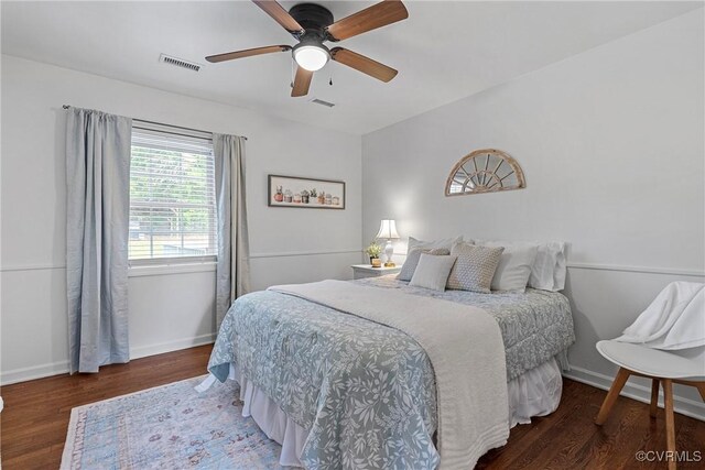 bedroom featuring visible vents, a ceiling fan, baseboards, and wood finished floors