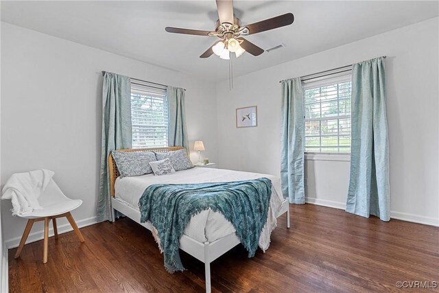 bedroom with a ceiling fan, baseboards, visible vents, and wood finished floors