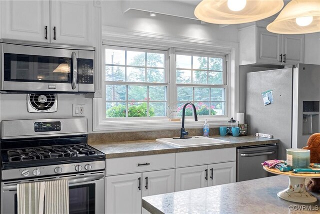 kitchen featuring a sink, appliances with stainless steel finishes, white cabinetry, and light countertops