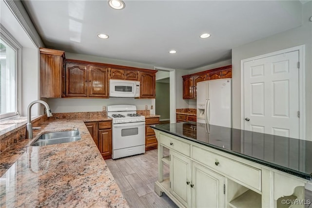 kitchen with white appliances, recessed lighting, a sink, and light wood finished floors