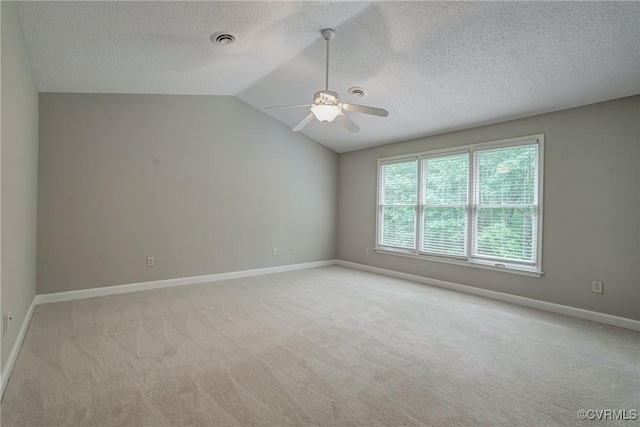 unfurnished room with ceiling fan, light colored carpet, a textured ceiling, baseboards, and visible vents