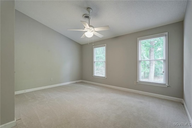 spare room featuring a ceiling fan, baseboards, and light carpet