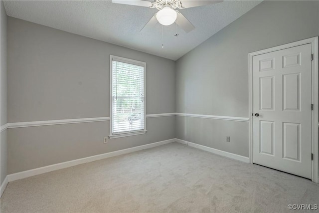 empty room with carpet floors, a ceiling fan, and baseboards