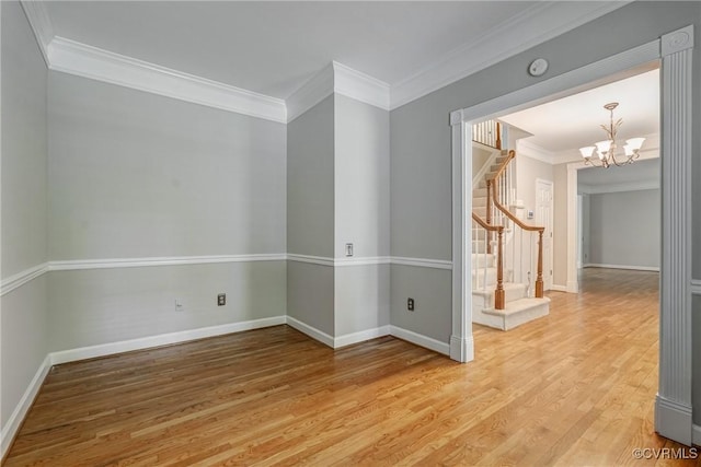 spare room with crown molding, baseboards, light wood finished floors, and stairs