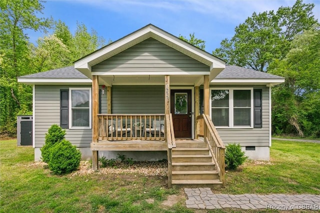 bungalow-style house with a porch, roof with shingles, crawl space, and a front yard
