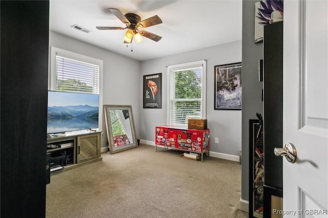 living area featuring baseboards, carpet, a ceiling fan, and visible vents
