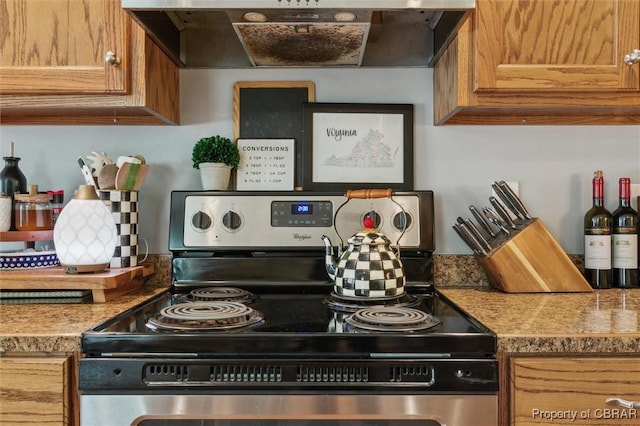kitchen with brown cabinetry, light countertops, electric range, and under cabinet range hood