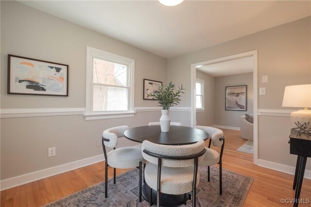 dining space with baseboards and light wood finished floors