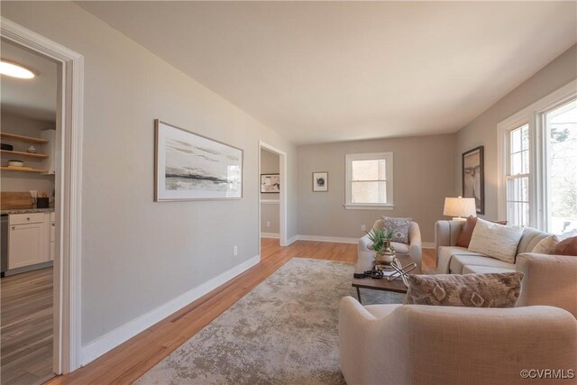 living area featuring baseboards and light wood-style flooring
