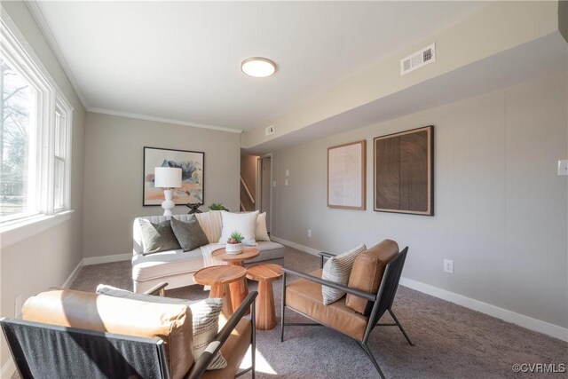 carpeted living area featuring visible vents, ornamental molding, and baseboards
