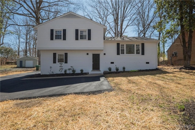 tri-level home featuring an outbuilding and a front yard