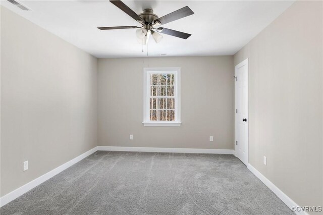 carpeted empty room featuring baseboards, ceiling fan, and visible vents