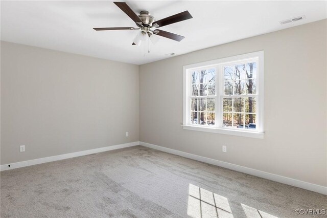 carpeted spare room with baseboards and visible vents