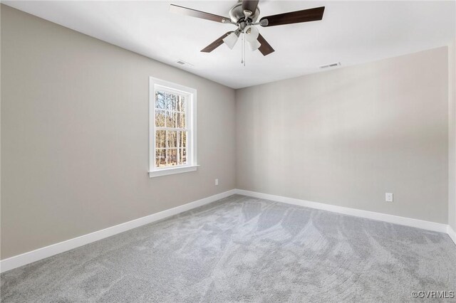 carpeted empty room with visible vents, baseboards, and ceiling fan