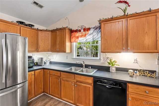 5841 Tuskwillow Dr, Richmond, VA 23832 - kitchen featuring brown cabinets, a sink, freestanding refrigerator, lofted ceiling, and black dishwasher