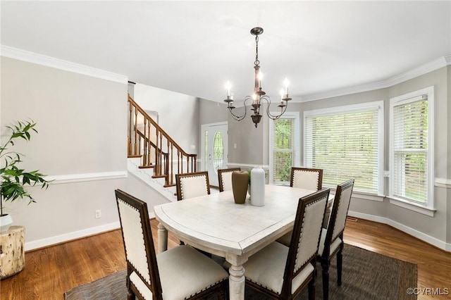 dining space with baseboards, a notable chandelier, plenty of natural light, and wood finished floors