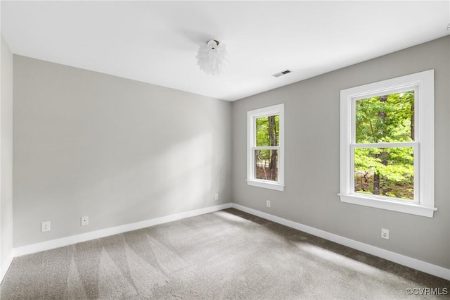 empty room with baseboards, carpet flooring, and visible vents