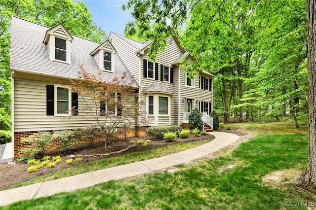 view of front of home featuring roof with shingles and a front lawn