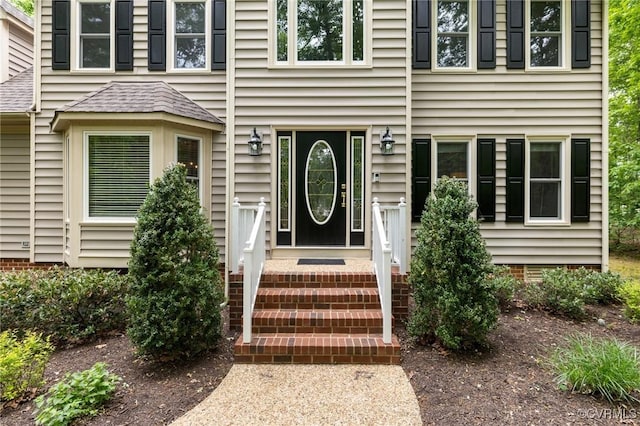 entrance to property featuring crawl space and roof with shingles