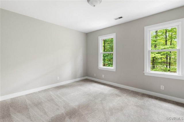 empty room featuring baseboards, carpet floors, and visible vents