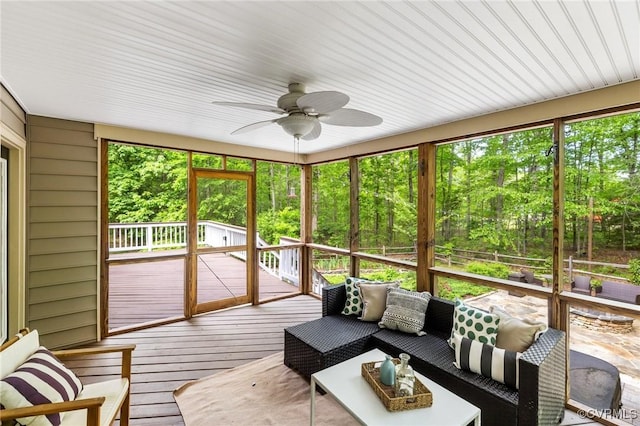 sunroom / solarium featuring a ceiling fan and an outdoor hangout area