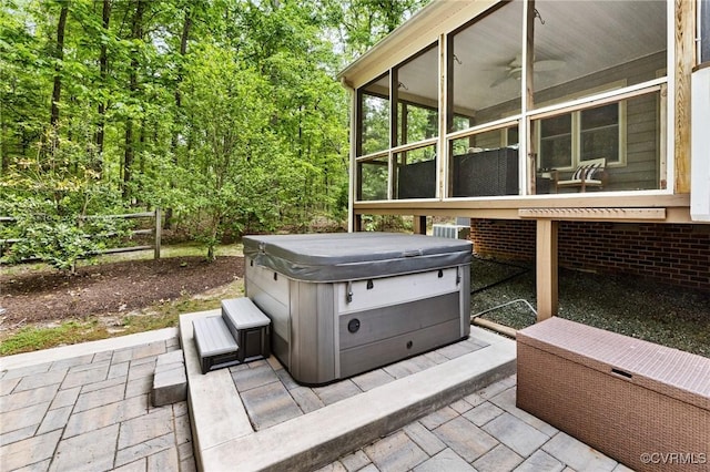 view of patio / terrace with a hot tub and a sunroom