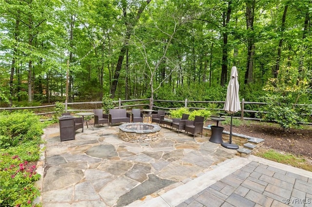 view of patio with an outdoor fire pit and fence