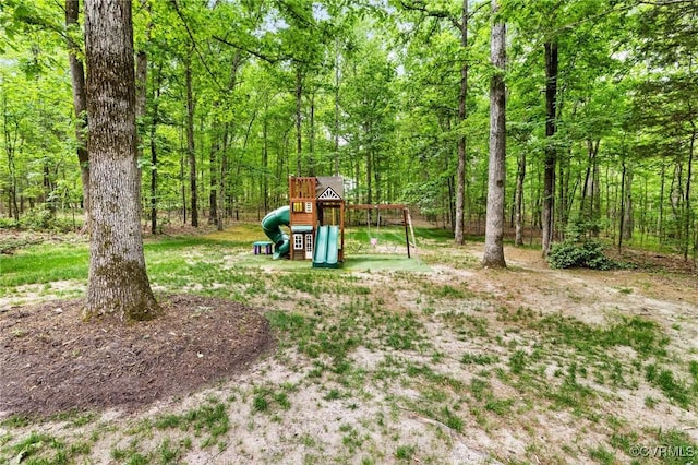 view of yard featuring a view of trees and a playground