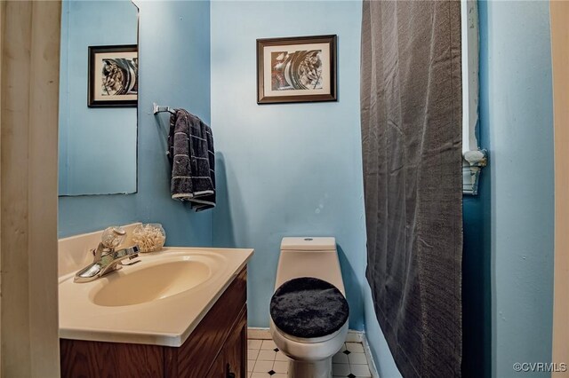 bathroom featuring vanity, baseboards, and toilet