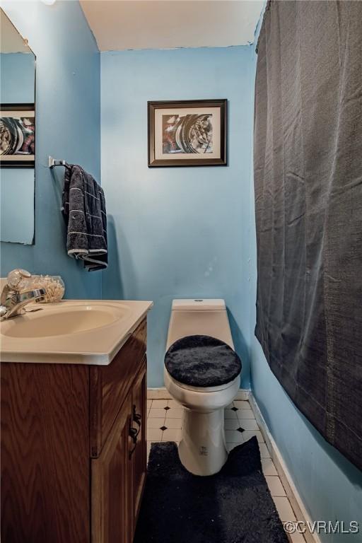 full bathroom featuring tile patterned floors, baseboards, vanity, and toilet