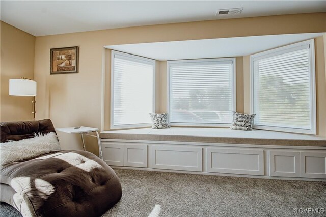 living area featuring light colored carpet and visible vents