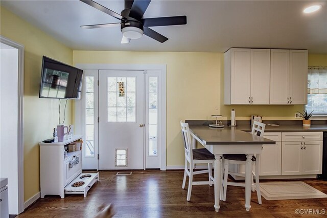 interior space featuring dark countertops, white cabinets, a ceiling fan, and dark wood-style flooring