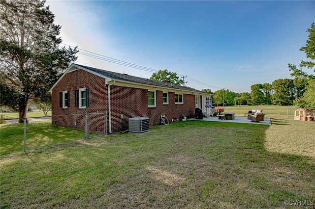 rear view of property featuring brick siding, central AC, fence, and a patio area