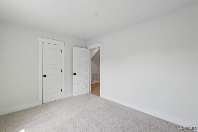 unfurnished bedroom with baseboards, carpet flooring, and visible vents
