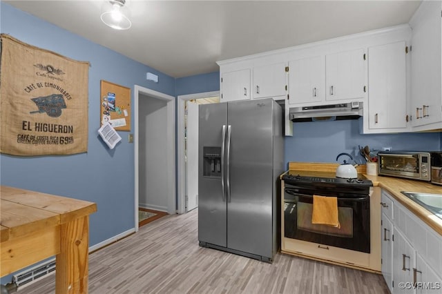 kitchen featuring a toaster, stainless steel fridge, white cabinetry, under cabinet range hood, and black range with electric stovetop