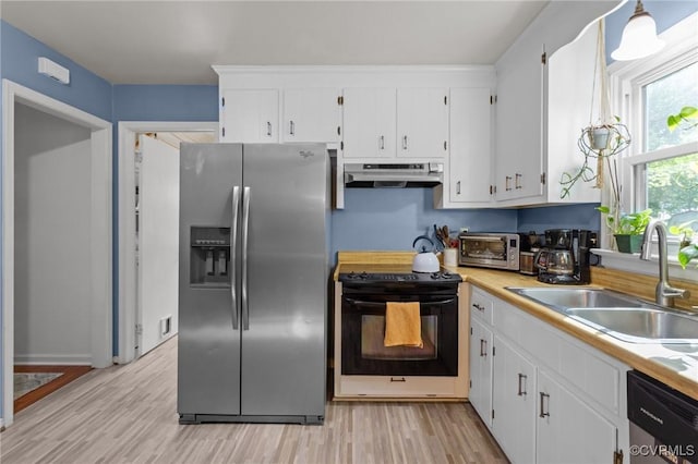 kitchen featuring appliances with stainless steel finishes, a sink, light countertops, under cabinet range hood, and white cabinetry