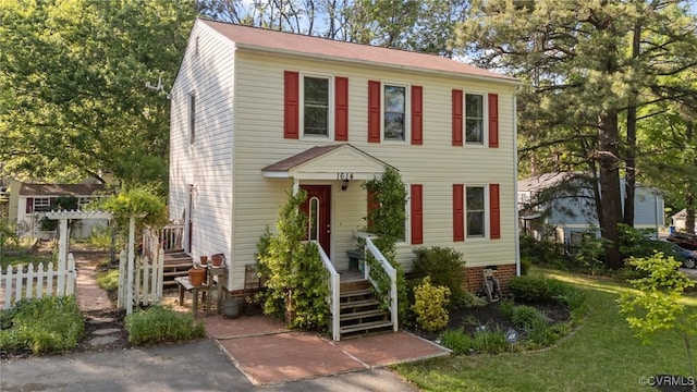 colonial-style house with fence and a front yard