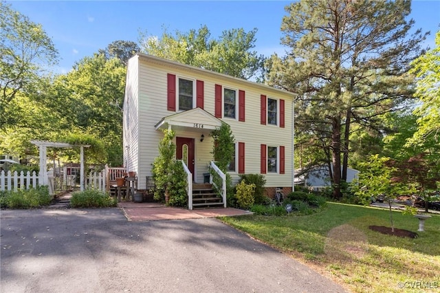 colonial house with fence and a front lawn