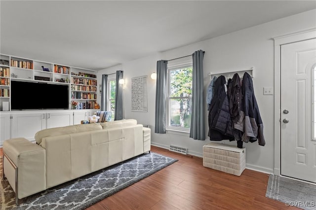 living area with visible vents, baseboards, and wood finished floors